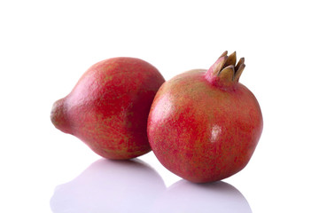 Pomegranate whole shot front on on a white background with reflection
