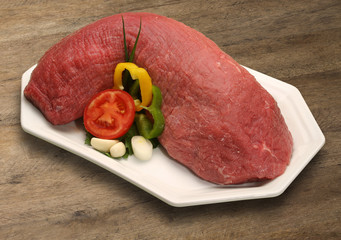 Raw meat selection on wooden cutting board with knife