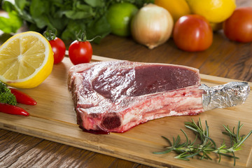 Raw meat selection on wooden cutting board with knife