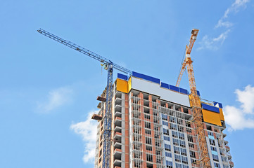 Crane and building construction site against blue sky