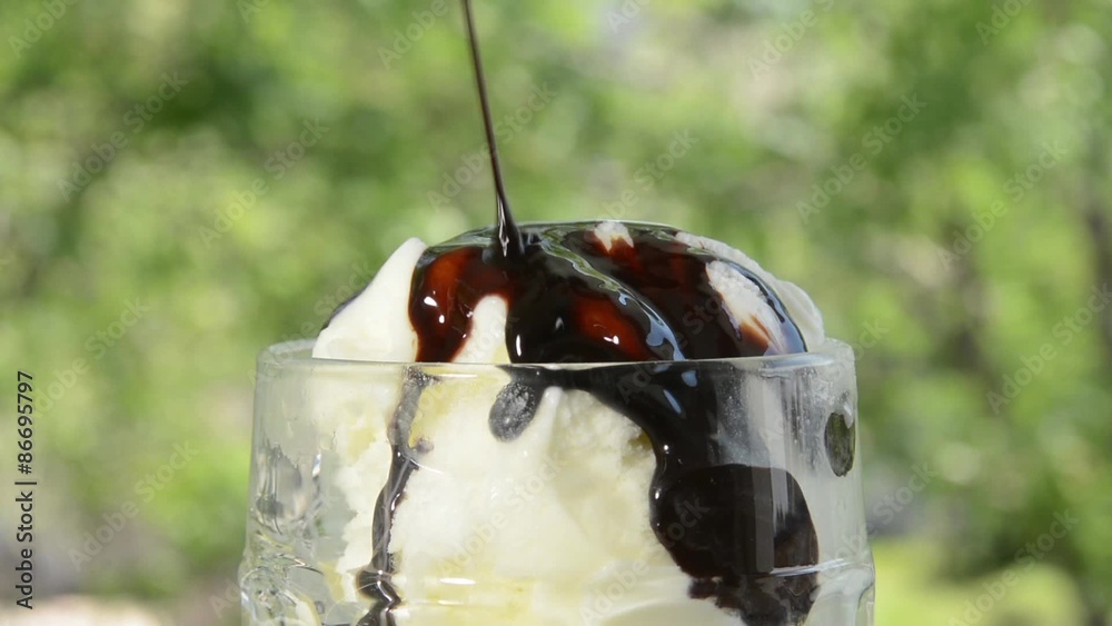 Wall mural pouring chocolate syrup on ice cream outdoors
