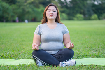 Asian woman meditating in garden