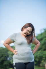 beautiful fat woman check her paunch in the garden