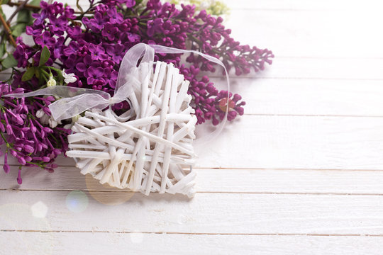  Decorative heart  and lilac flowers on wooden background.