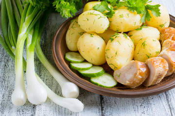 Young boiled potatoes with dill, sausage, cucumber, parsley and