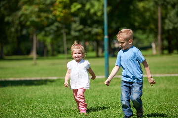 Boy and girl have fun and running in park