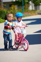 Fototapeta premium Boy and girl in park learning to ride a bike
