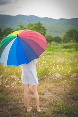 Outdoor portrait of asian girl waiting for some one with rainbow
