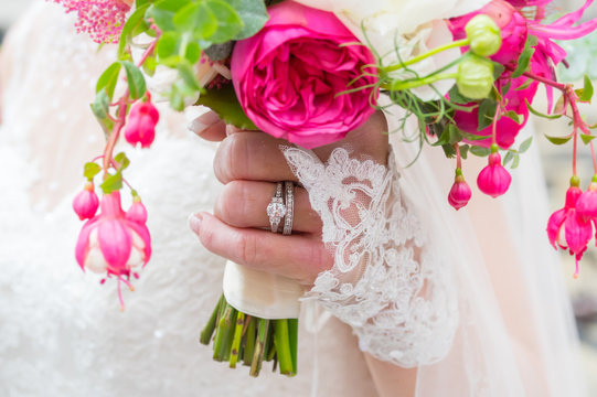 Hand der Braut mit Ehering und Brautstrauß