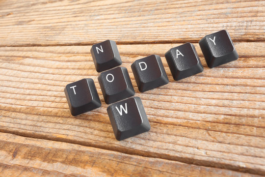 "TODAY NOW" wrote with keyboard keys on wooden background
