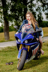 Fototapeta na wymiar beautiful young woman with a motorcycle speed in nature