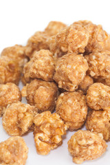 Almond and caramal popcorn on white background