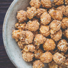 Almond and caramal popcorn on wood background