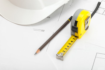 Measuring tape, construction helmet and pencil