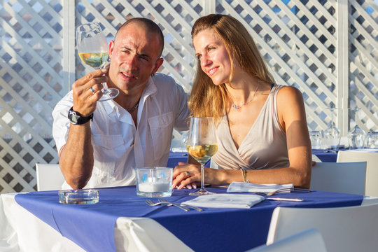 Young adult couple drinking wine in outdoor  restaurant 