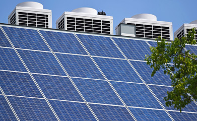 Solar panels and air conditioners on the roof of a building