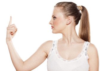 serious young blonde pointing a finger at an imaginary object