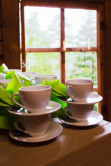 White cups and saucers standing exactly on the table