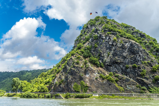 Gr&uuml;ner Loreleyfelsen am Rhein strahlt unter wei&szlig;-blauem Himmel