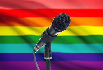 Microphone on stand with national flag on background - LGBT