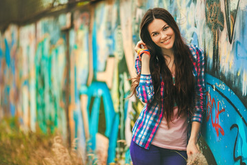 Naklejka premium The girl against a wall with graffiti.