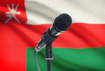 Microphone on stand with national flag on background - Oman