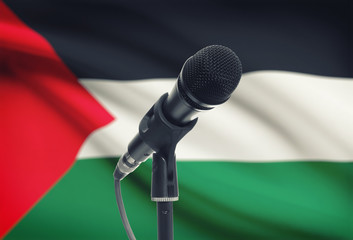 Microphone on stand with national flag on background - Palestine