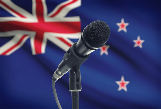 Microphone on stand with national flag on background - New Zealand