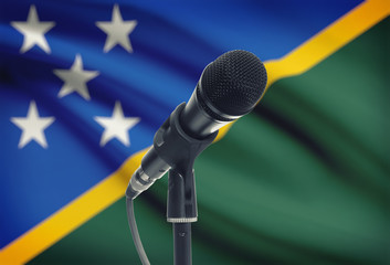 Microphone on stand with national flag on background - Solomon Islands