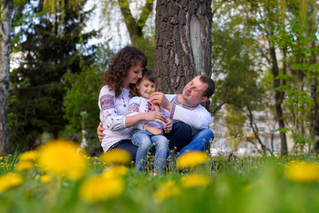 Naklejka na ściany i meble happy Ukrainian family dad mother and daughter on nature