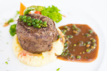 Beef steak on mashed potatoes with black pepper sauce