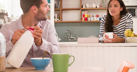 Young Couple Eating Breakfast In Kitchen Together