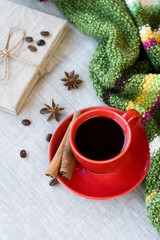 Red cup of coffee with coffee beans and spices cinnamon and anis