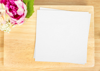 Top view of Blank wooden plate with white paper and flower pot o