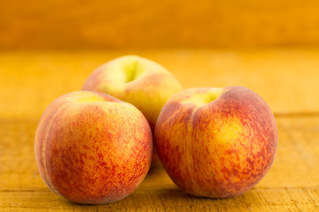 ripe fresh peaches on wooden background