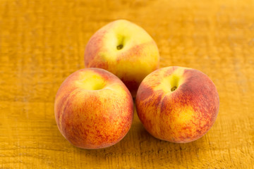 ripe fresh peaches on wooden background