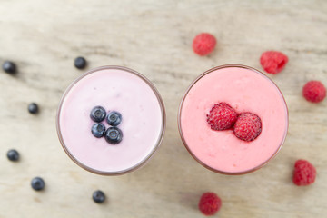 Raspberry and blueberry smoothie with berries on wooden background. Healthy vegetarian food, diet.