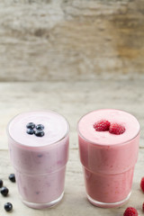 Raspberry and blueberry smoothie with berries on wooden background. Healthy vegetarian food, diet.