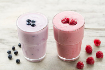 Raspberry and blueberry smoothie with berries on wooden background. Healthy vegetarian food, diet.
