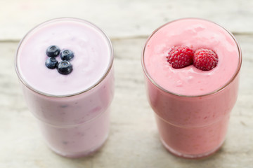 Raspberry and blueberry smoothie with berries on wooden background. Healthy vegetarian food, diet.