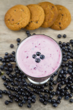 Blueberry smoothie with berries on wooden background. Healthy vegetarian food, diet.