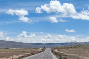 strada dritta su altopiano andino. Peru . Cielo blu con nuvole bianche all'orizzonte