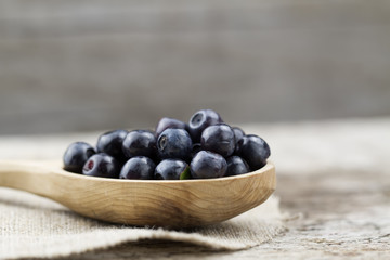 fresh blueberries in spoon on wooden background, close-up