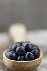 fresh blueberries in spoon on wooden background, close-up