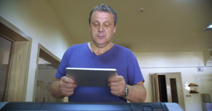 Man with touch pad exercising on treadmill