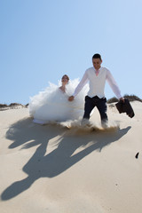 Beautiful wedding couple at the beach with wedding dress