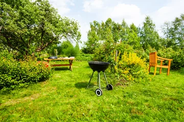 Rolgordijnen Beautiful view on garden with grill, table, chair © Sergey Novikov