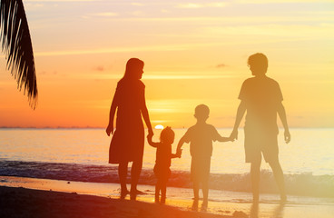 Fototapeta na wymiar happy family with two kids on sunset beach