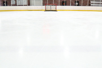 Naklejka premium Perspective of a tiny hockey net across expansive ice at an indoor rink
