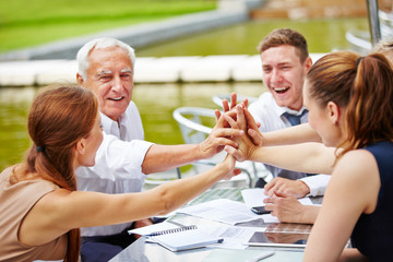 Geschäftsleute machen High Five beim Meeting